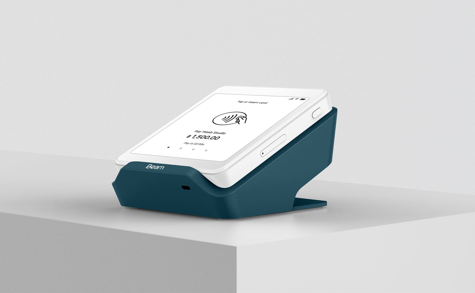 Hand holding a payment terminal, scanning a QR code on a phone